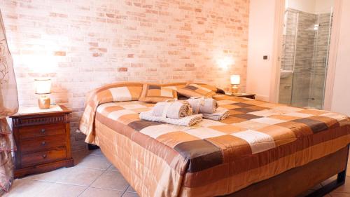 una camera con un grande letto e un muro di mattoni di PM 12 Via Achille Grandi Guest House ad Alghero