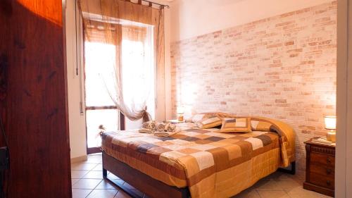um quarto com uma cama com uma parede de tijolos em PM 12 Via Achille Grandi Guest House em Alghero