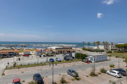 a parking lot with cars parked in front of a harbor at Hotel Quisisana in Vada