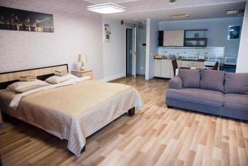 1 dormitorio con cama, sofá y cocina en Papiniidu Studio Apartments, en Pärnu