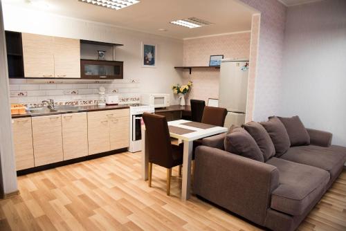 ein Wohnzimmer mit einem Sofa und einem Tisch sowie eine Küche in der Unterkunft Papiniidu Studio Apartments in Pärnu