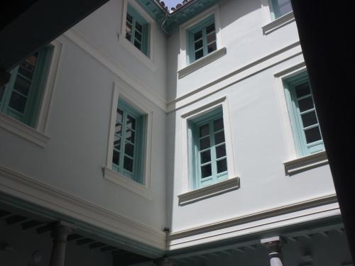 a white building with green windows at Palacio Cabrera - Lillo in Granada