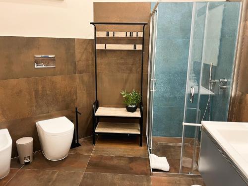 a bathroom with a toilet and a glass shower at Al 115 Rooms in Cagliari