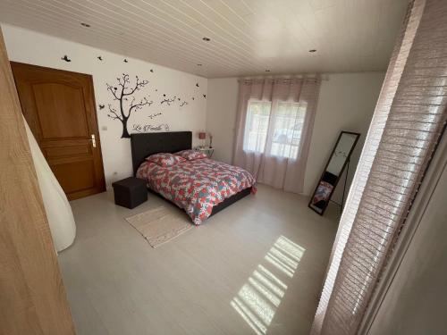 a bedroom with a bed and a tree on the wall at Les Demoiselles du Lac in Braucourt