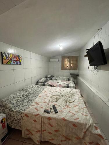 2 camas en una habitación con TV en la pared en Pousada do Gordo en Bonito