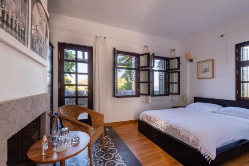ボズジャ島にあるAkvaryum Hotelのベッドルーム1室(ベッド1台、テーブル、窓付)