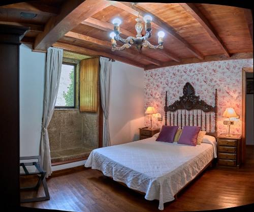 a bedroom with a bed and a chandelier at Casa de Casal in Lestedo