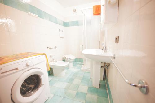 a bathroom with a washing machine and a toilet at Casa Pamalù in Nisporto