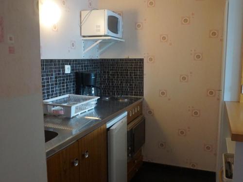 une cuisine avec un évier et un micro-ondes dans l'établissement Appartement 2P à Orcières Merlette, 6 pers, animaux acceptés, proche pistes et commerces - FR-1-636-99, à Orcières