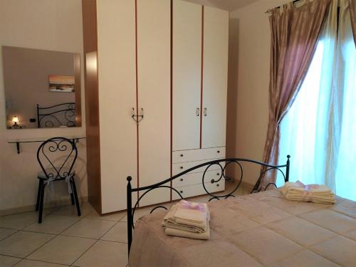 a bedroom with a bed and a chair and a window at Alice B&B in Càbras
