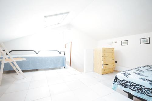 a white bedroom with a bed and a dresser at Casa Pamalù in Nisporto
