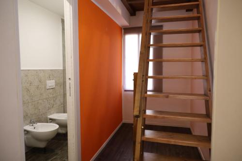 uma casa de banho com uma escada de madeira que leva a um WC em AGroom em Bari