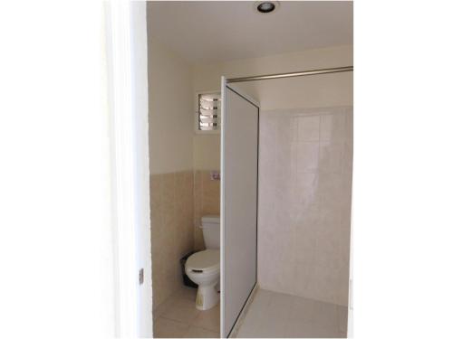a bathroom with a toilet and a glass shower door at Hotel Ma Elena in Isla Mujeres