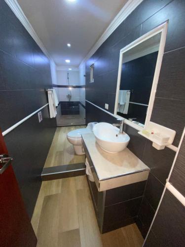 bagno con lavandino, specchio e 2 servizi igienici di Hotel Vicentina a Boca Chica