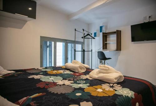 - une chambre avec un lit à motifs floraux et des serviettes dans l'établissement Le PANIER DE PAPET,LE MANON,VIEUX PORT,MUCEM, à Marseille