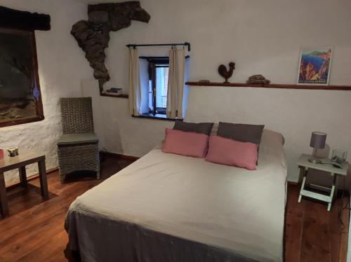 1 dormitorio con 1 cama con 2 almohadas rosas en Sole e Ventu 30qm, en San-Giovanni-di-Moriani
