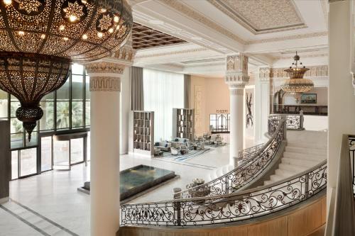 eine große Lobby mit einer Treppe und einem Kronleuchter in der Unterkunft Al Ahsa InterContinental, an IHG Hotel in Al-Hasa
