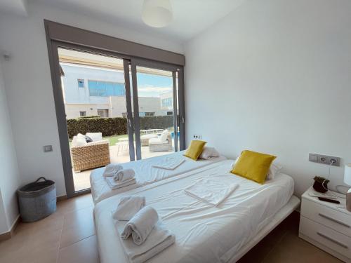 1 dormitorio con 1 cama blanca grande con almohadas amarillas en 3091 Villa MALIBU, en Orihuela