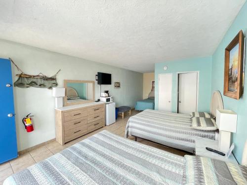 a hotel room with two beds and a television at Beach Colony Motel in Wildwood Crest