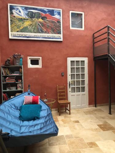 Cette chambre comprend un lit et une affiche murale. dans l'établissement LIMOUX RIVERSIDE GARDENs, à Limoux