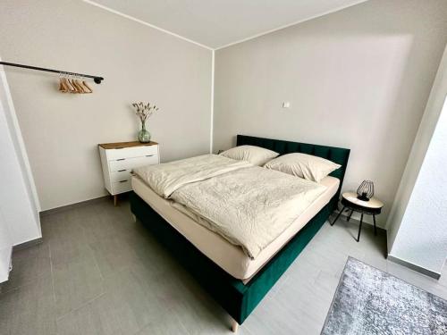 a bedroom with a large bed and a night stand at Ferienwohnung komfortabel Wohnen Bremerhaven in Bremerhaven