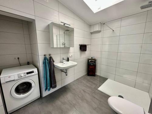 a bathroom with a washing machine and a sink at Ferienwohnung komfortabel Wohnen Bremerhaven in Bremerhaven