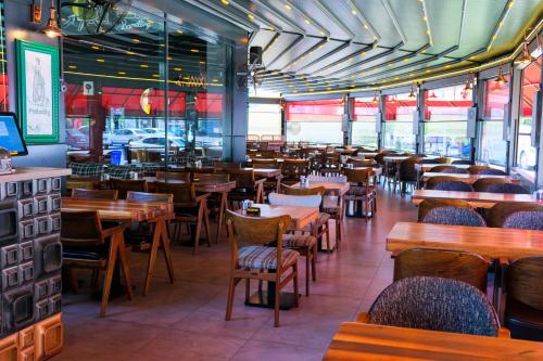 a dining room with wooden tables and chairs at Brand Business Hotel in Corlu