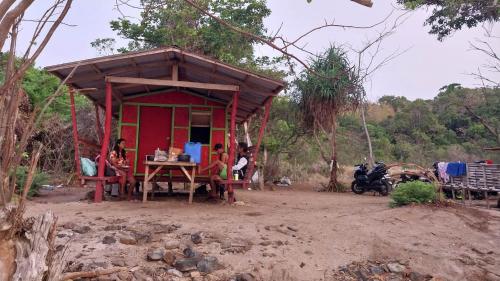 a small red house with people sitting in front of it at Masamirey Endpoint Cottages Rental in Sual