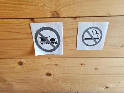 two no parking signs on a wooden wall at LOGIS LAS CROZAS La Cocotte in Vernines