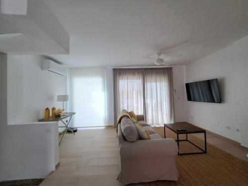 Una sala de estar blanca con un sofá y una mesa. en El lugar ideal, en Vera
