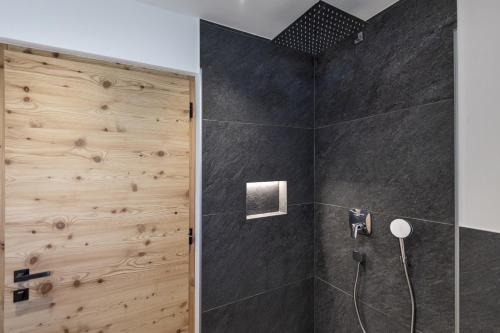 a bathroom with a shower with a wooden wall at Chalet Berna in Ortisei