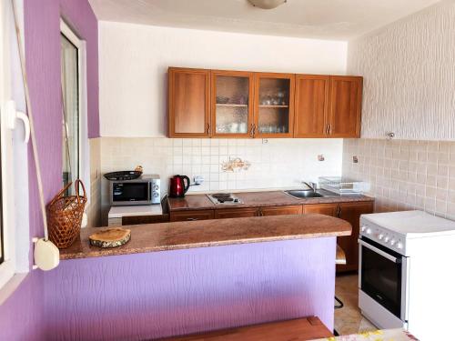 a kitchen with wooden cabinets and a counter top at Villa Blanca in Utjeha