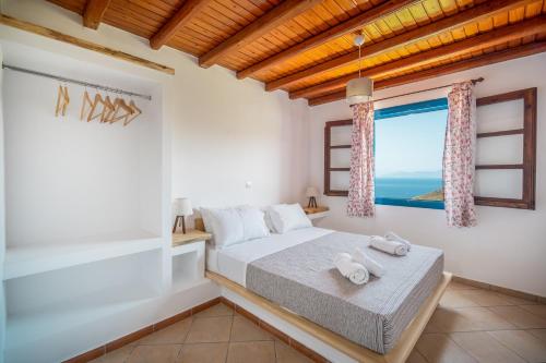 a bedroom with a bed and a large window at Niel Serifos in Serifos Chora