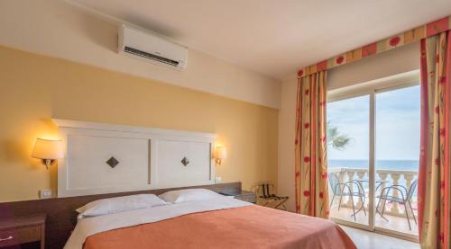 a bedroom with a bed with a view of the ocean at Hotel Orizzonte in Letojanni