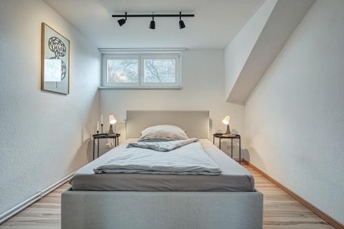 Bett in einem Zimmer mit 2 Tischen und einem Fenster in der Unterkunft Residenz unter den Linden Falke in Mühlhausen