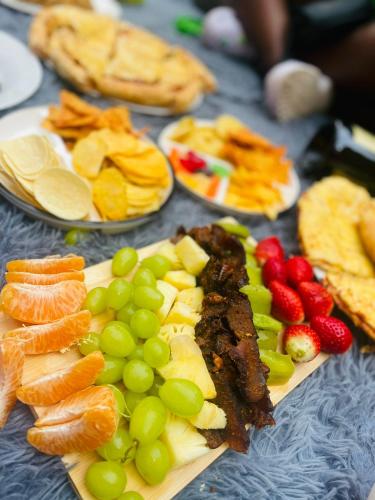 a table topped with plates of fruits and vegetables at Airport Royal Guest House in Kempton Park