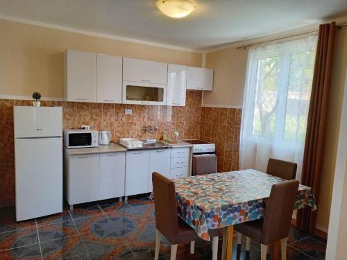 バールにあるKIWIのテーブルと白い冷蔵庫のあるキッチン