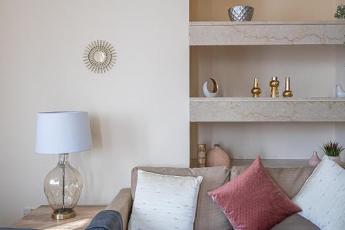 a living room with a couch with pillows and a lamp at HiGuests - Cheerful Apt With Stunning Views in Port Saeed in Dubai