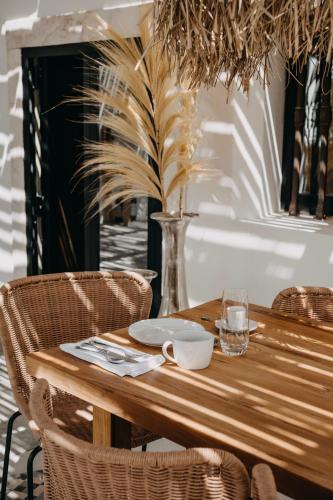 a wooden table with chairs and a vase at Casa Az-Zagal - by Unlock Hotels in Casa Branca