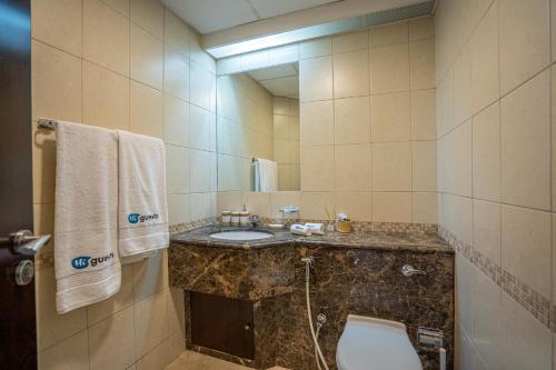 a bathroom with a sink and a toilet and a mirror at HiGuests - Cheerful Apt With Stunning Views in Port Saeed in Dubai