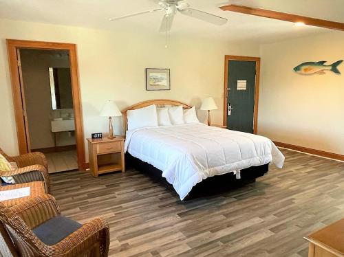 a hotel room with a bed and a chair at Pony Island Inn in Ocracoke