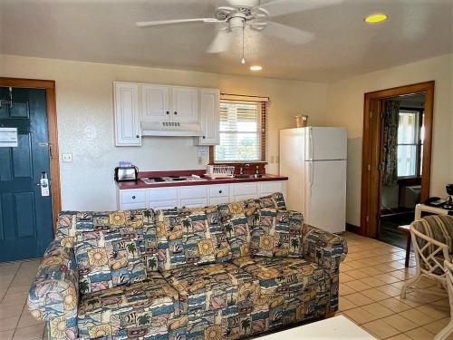 a living room with a couch and a kitchen at Pony Island Inn in Ocracoke
