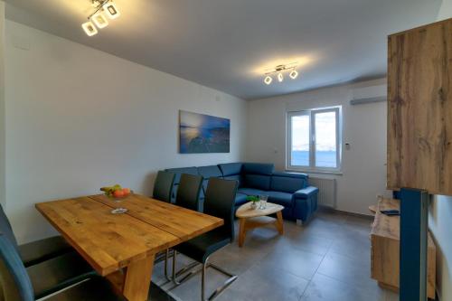a dining room with a table and a blue couch at Villa Panorama in Senj