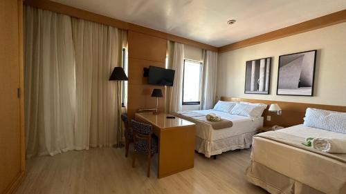 een hotelkamer met 2 bedden en een bureau bij NIPS 1309 - Ótimo Apto Alto do Tatuapé in Sao Paulo
