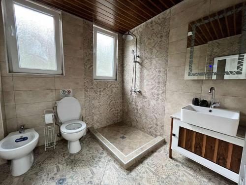 ein Badezimmer mit einem WC, einem Waschbecken und einem Spiegel in der Unterkunft Apartment Enina in Weliko Tarnowo