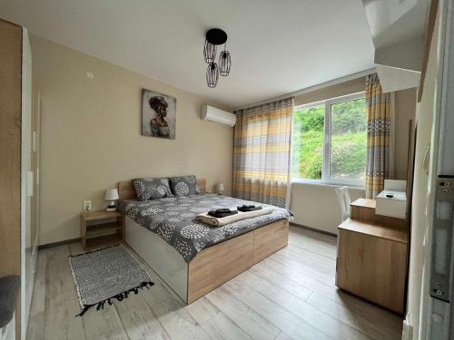 ein Schlafzimmer mit einem Bett und einem großen Fenster in der Unterkunft Apartment Enina in Weliko Tarnowo