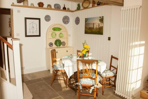 a dining room with a table and chairs at The Cottage in Cross in Hand