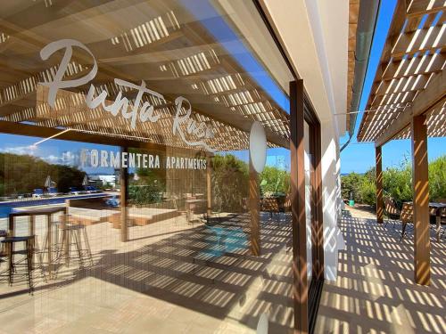 a view of a patio with a sign on a building at Punta Rasa Formentera Apartments in Cala Saona