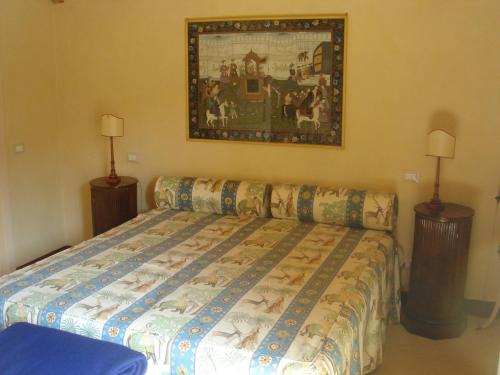 una camera da letto con un letto e un dipinto sul muro di La Monella a Carpaneto Piacentino