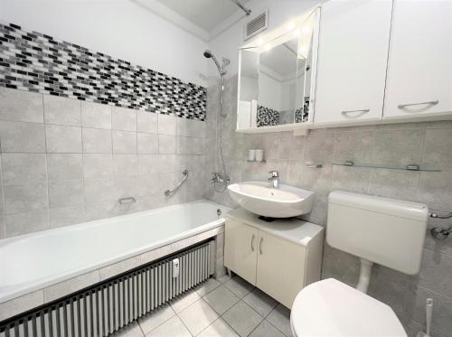 uma casa de banho com um lavatório, uma banheira e um WC. em Panoramic App A05-2 em Sierksdorf